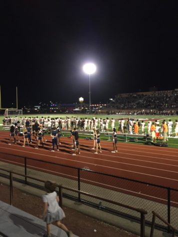 Football players stand during the national anthem before a game.