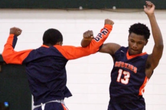 Dashon Enoch jumps and celebrates with teammate Daryl Davis during a game.