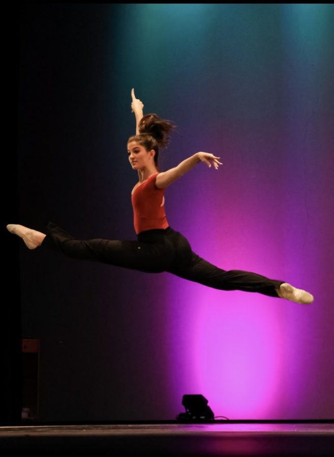 Addie Heskett leaping across the stage