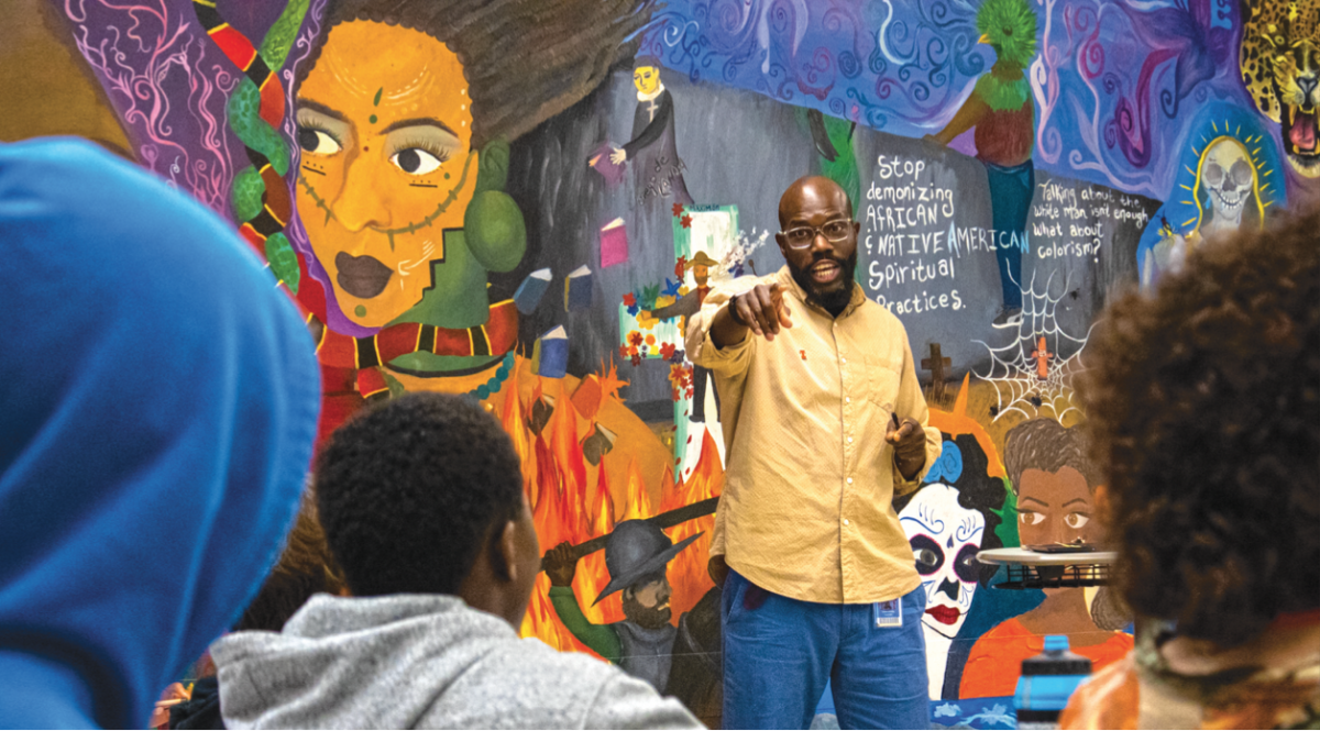 Williams teaching in front of the mural in his classroom