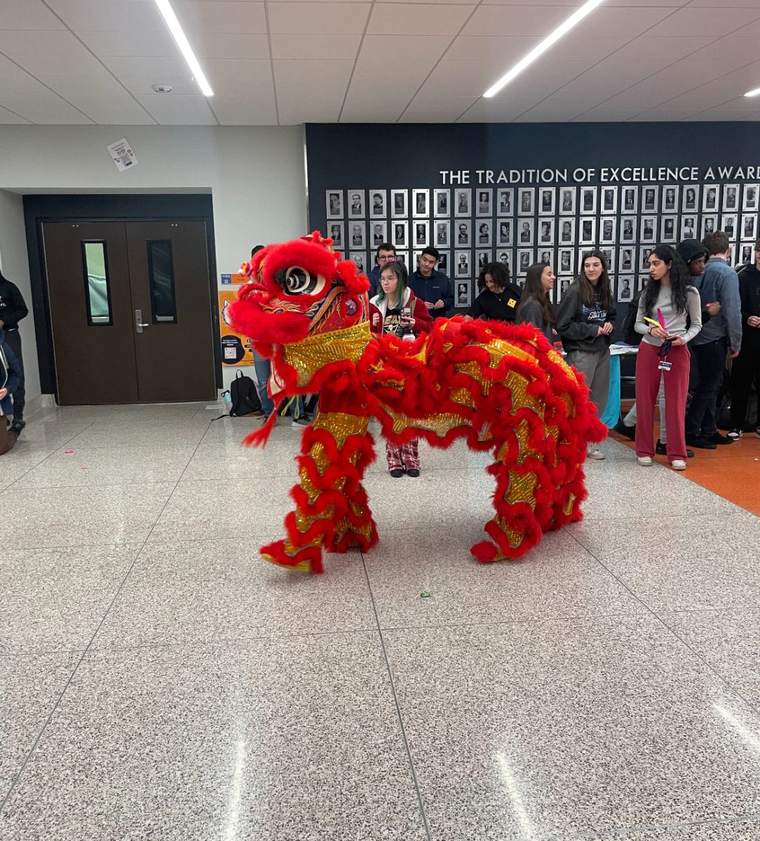 Students watch as the Lunar New Year dragon makes its way through the commons.