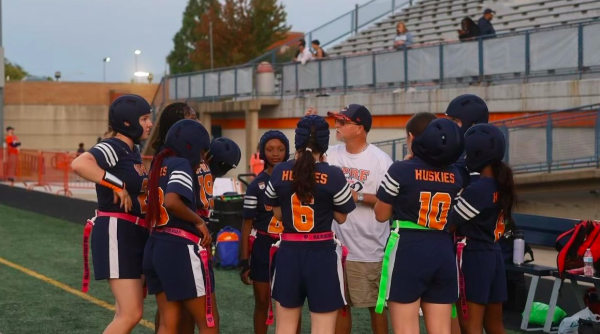 Girls flag football joined for a huddle during a timeout.