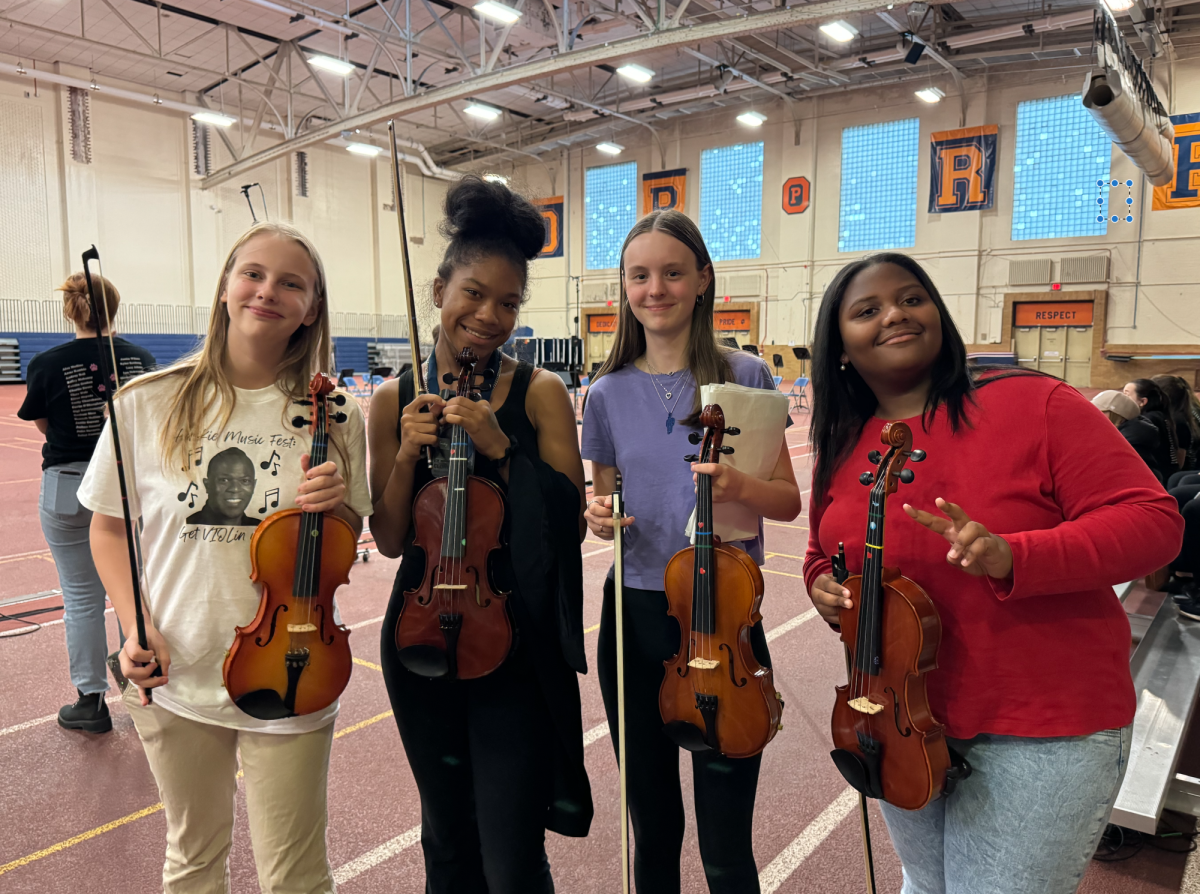 Porcshe’ Murphy, Lily Kleps, Paris King and Jessica Brooks posing with violins.