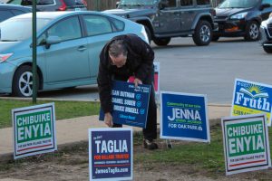 Bruce Brigell adding a lawn sign before the April 1 election