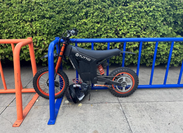 An e-bike parked at a bike rack on the Mall west of the school building