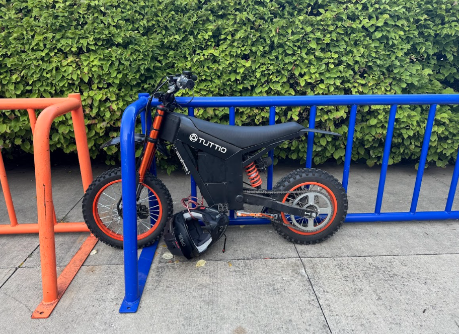 An e-bike parked at a bike rack on the Mall west of the school building