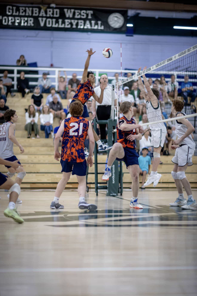 Trayce Chrusfield spikes the ball as Wesley Kochendorfer, Matthew Proskey and Gus Leman look on.