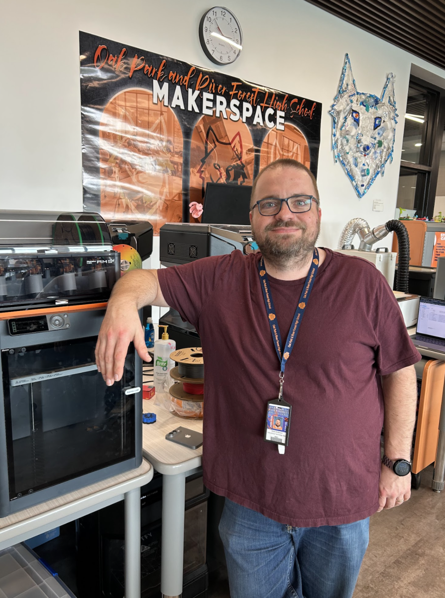 Anderson leans against a 3D printer in the Student Resource Center.